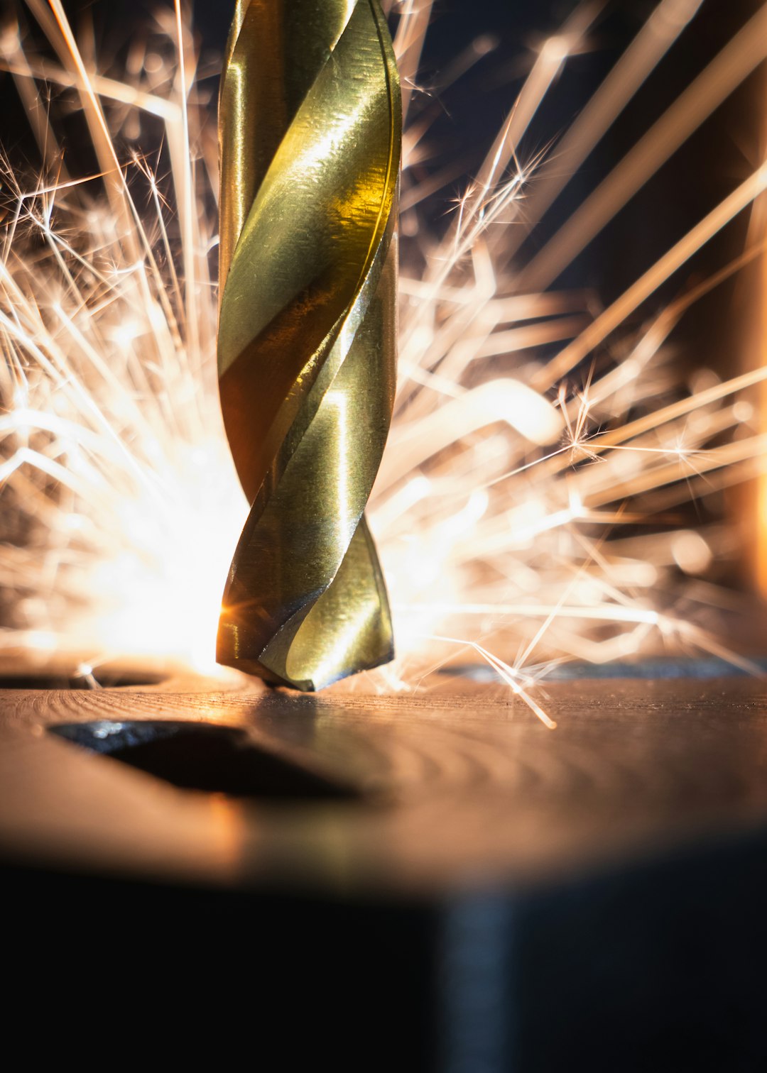 industrial drill bit with sparks in the distance